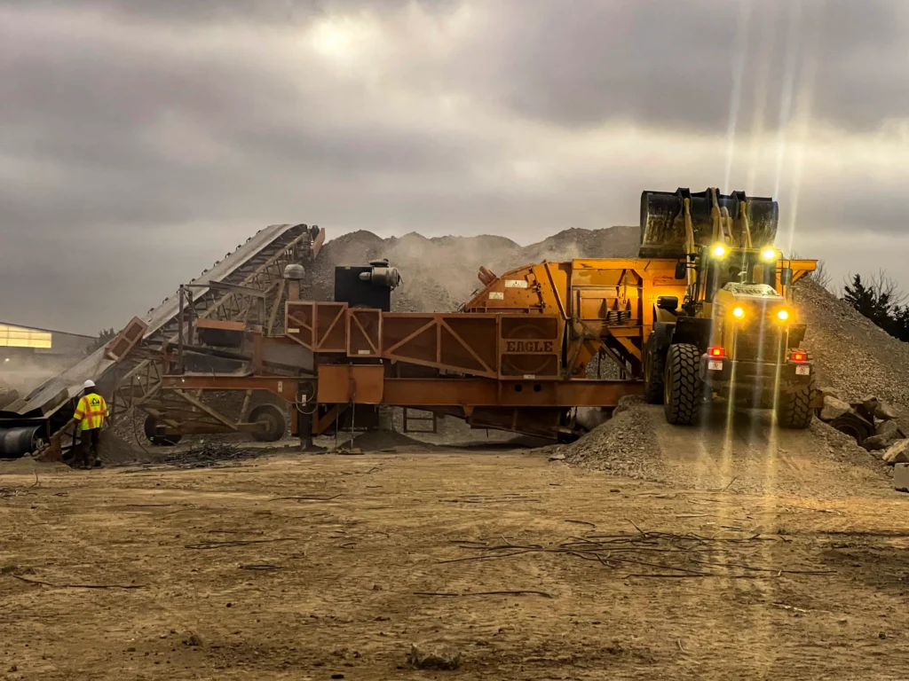 Wheel loader feeding Eagle crusher at a material processing site