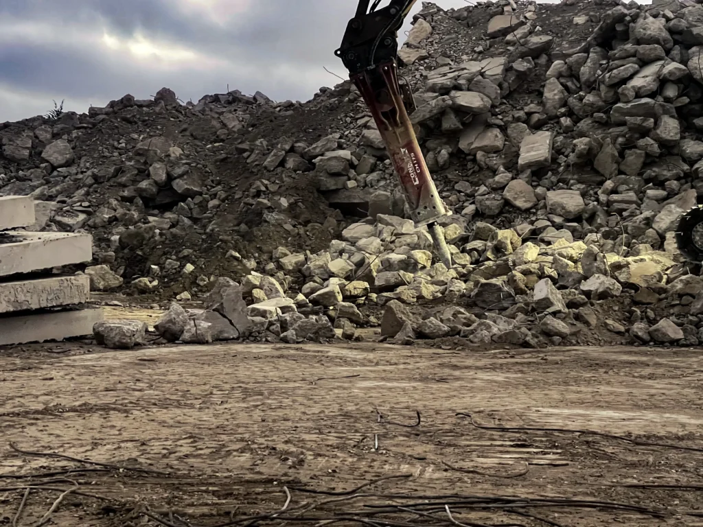 Hydraulic breaker breaking rock at a demolition site
