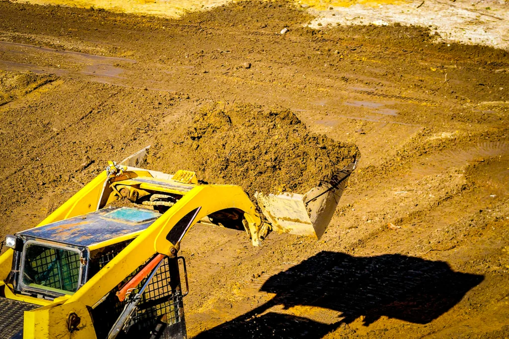 Aerial view of skid steer moving dirt during site work