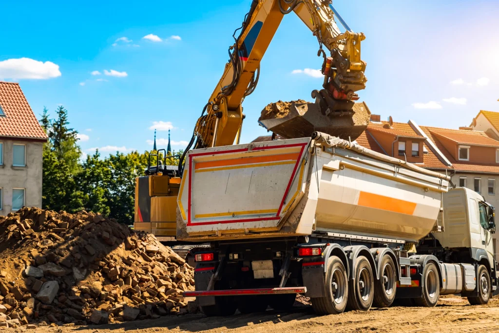 Excavator loading dirt into a dump truck on a job site