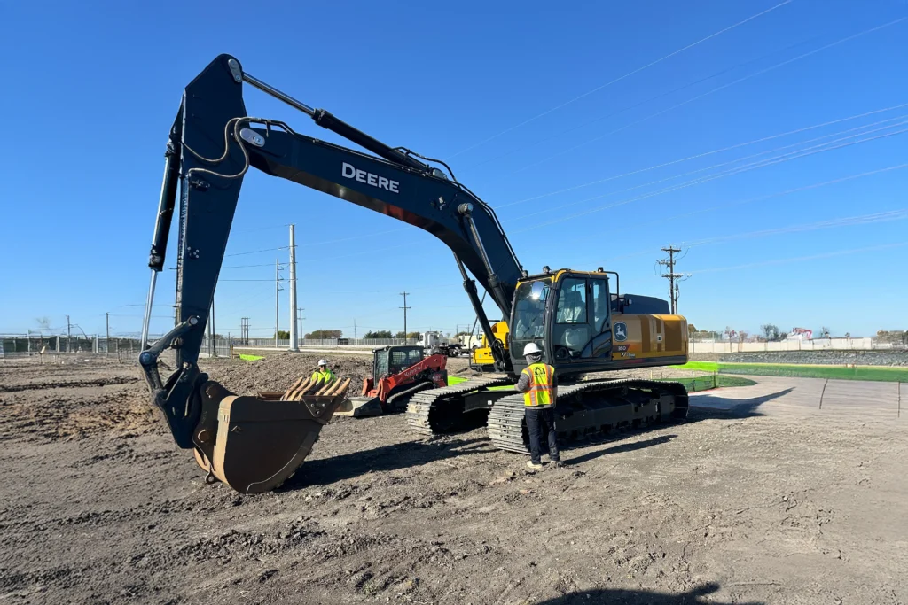 John Deere excavator with operator on a commercial job site