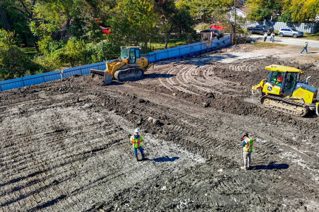 Aerial view of crew and equipment grading a residential lot